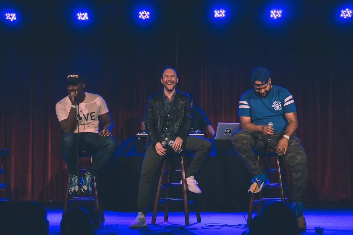 Woke Bros on stage in Brooklyn, with Michael Brooks in the middle